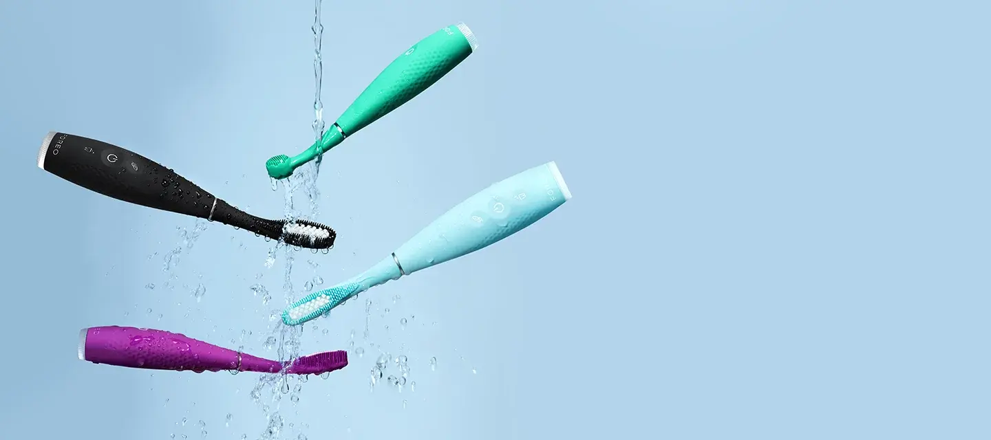 Issa 4 collection silicone sonic electric toothbrushes mid air on a light blue background